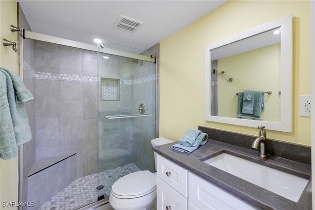 bathroom with an enclosed shower, vanity, and toilet