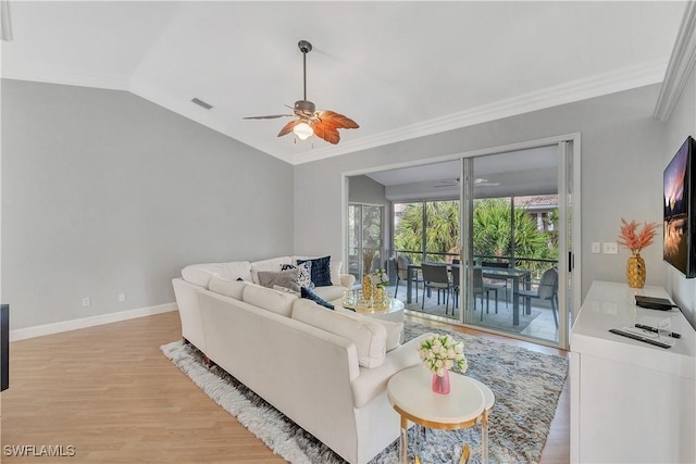 living room with light wood-type flooring, vaulted ceiling, ceiling fan, and crown molding