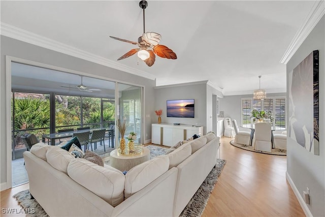 living room featuring ceiling fan with notable chandelier, light hardwood / wood-style floors, and ornamental molding