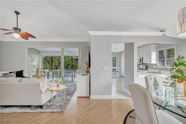 living room featuring light hardwood / wood-style floors, crown molding, and sink