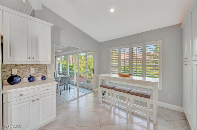 dining space featuring light tile patterned floors and lofted ceiling