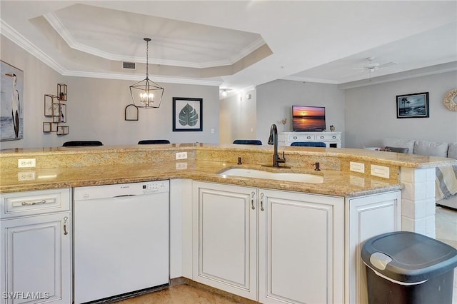 kitchen featuring ceiling fan with notable chandelier, a tray ceiling, sink, dishwasher, and white cabinetry