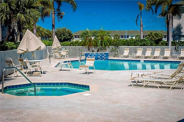 view of pool with a hot tub and a patio area