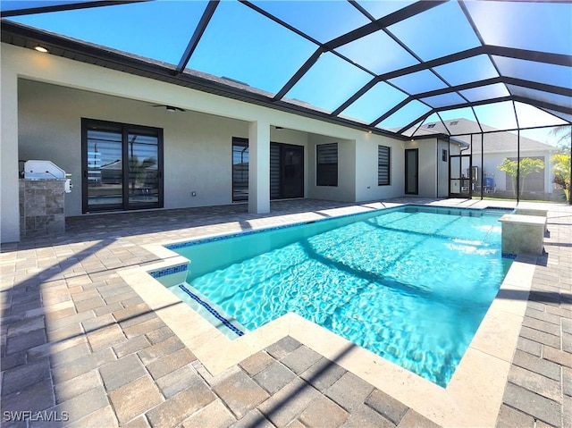 view of pool with pool water feature, glass enclosure, and a patio