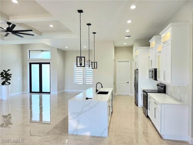 kitchen featuring a large island, sink, hanging light fixtures, white cabinets, and appliances with stainless steel finishes