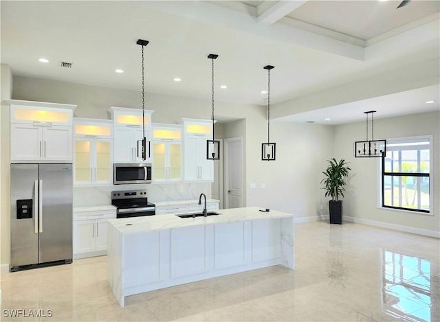 kitchen featuring stainless steel appliances, white cabinetry, a center island with sink, and sink