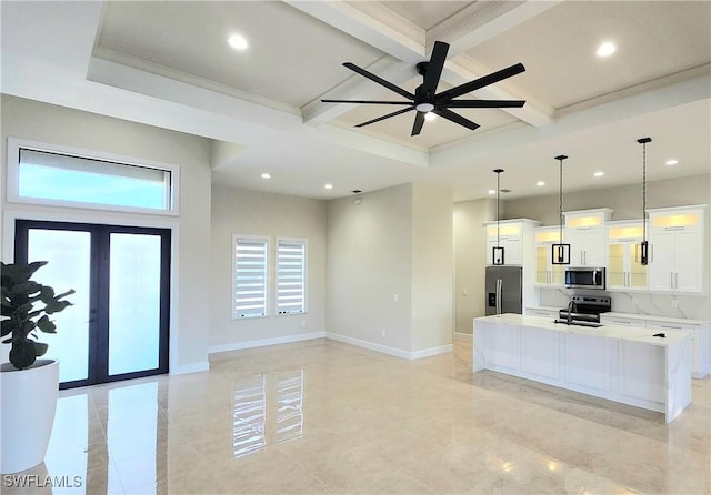 kitchen with decorative light fixtures, stainless steel appliances, white cabinetry, and a kitchen island