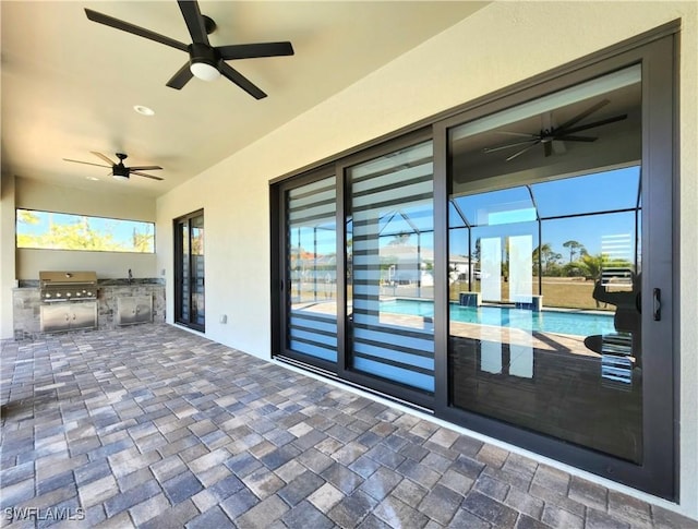 view of patio featuring area for grilling, exterior kitchen, and glass enclosure