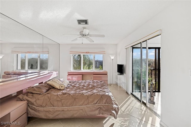 bedroom featuring access to outside, multiple windows, visible vents, and a textured ceiling