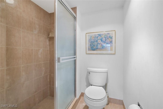 full bath with toilet, a shower stall, and tile patterned flooring