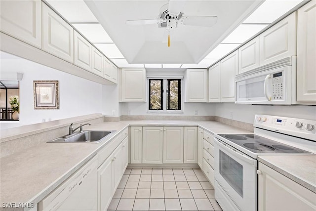 kitchen featuring a tray ceiling, white cabinetry, white appliances, light countertops, and light tile patterned floors