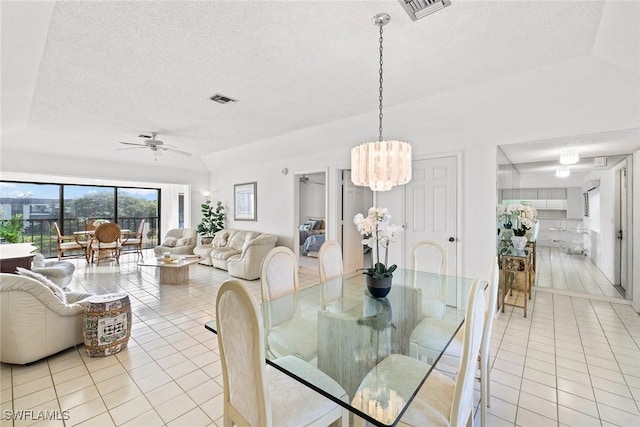 dining room with light tile patterned floors, ceiling fan with notable chandelier, visible vents, and a textured ceiling