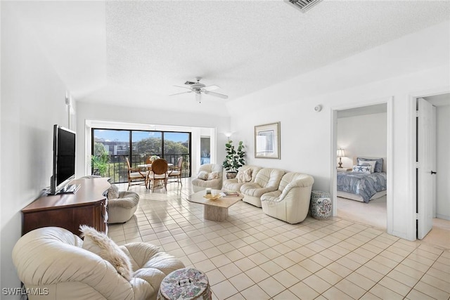 living room with light tile patterned floors, visible vents, a textured ceiling, and a ceiling fan