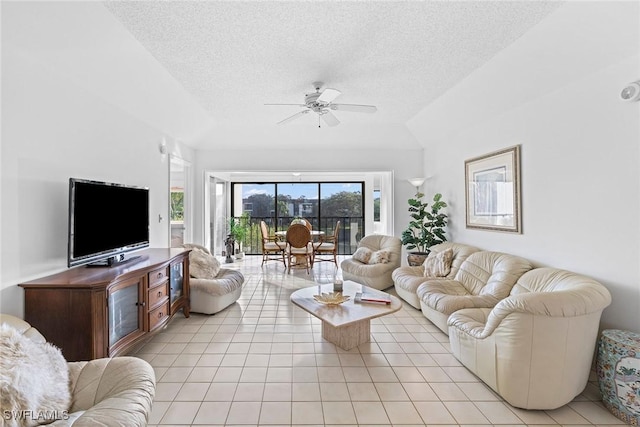 living room with a textured ceiling, vaulted ceiling, light tile patterned floors, and ceiling fan