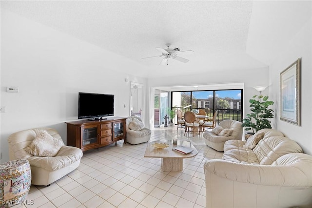 living area featuring light tile patterned floors, a textured ceiling, and a ceiling fan