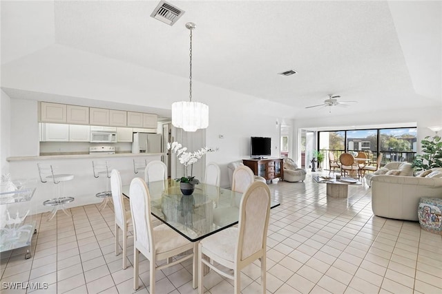 dining area featuring light tile patterned flooring, ceiling fan with notable chandelier, and visible vents