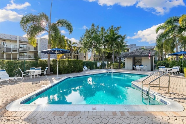 pool featuring fence and a patio area