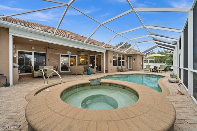 view of pool with ceiling fan, a patio, and a pool with connected hot tub