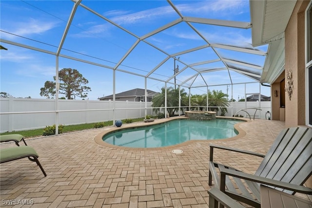 view of swimming pool featuring a patio area, a fenced backyard, a pool with connected hot tub, and a lanai