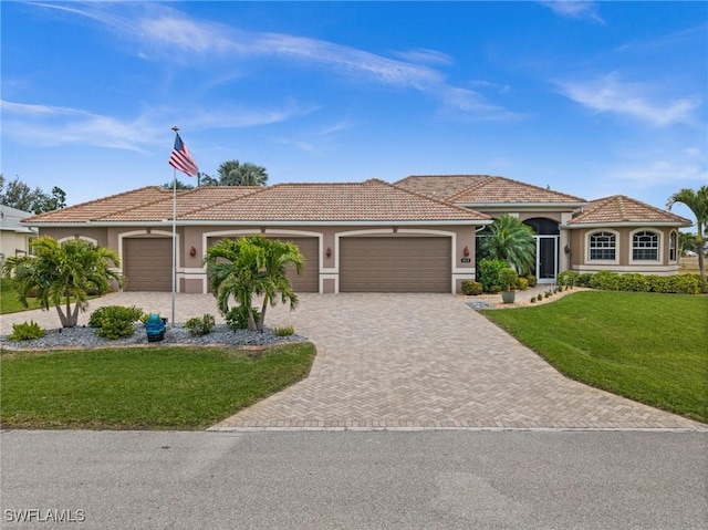 view of front facade featuring stucco siding, a front yard, decorative driveway, and a garage