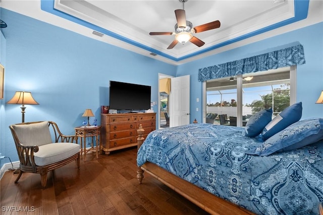 bedroom featuring access to exterior, a raised ceiling, visible vents, and hardwood / wood-style flooring