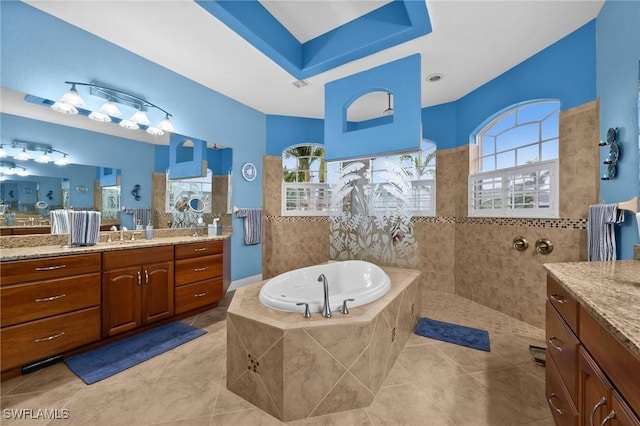 bathroom featuring tile patterned floors, walk in shower, a bath, and vanity