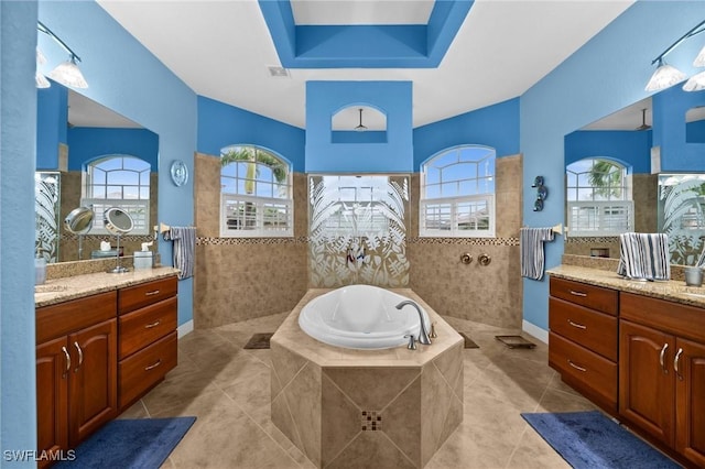 bathroom with a bath, tile patterned flooring, a walk in shower, and two vanities