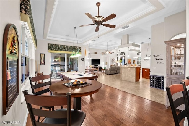 dining area featuring light wood finished floors, visible vents, a raised ceiling, and pool table