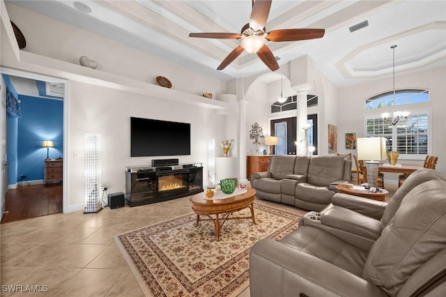 living room featuring decorative columns, visible vents, a raised ceiling, baseboards, and light tile patterned flooring