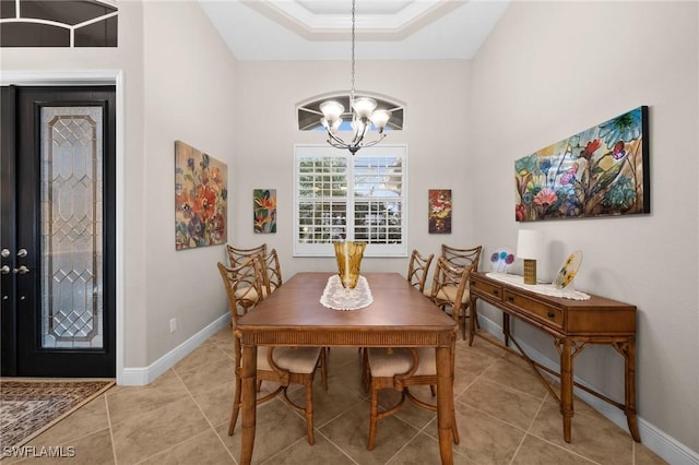 dining area featuring a chandelier, light tile patterned floors, and baseboards