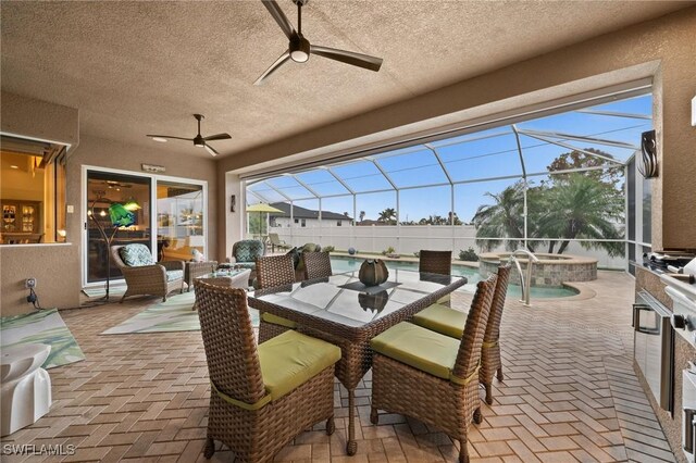 view of patio / terrace with glass enclosure, a pool with connected hot tub, outdoor dining area, and a ceiling fan