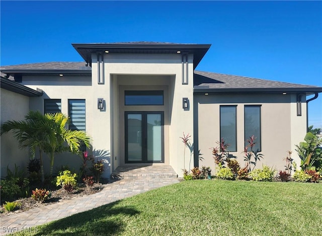 entrance to property featuring a lawn and french doors