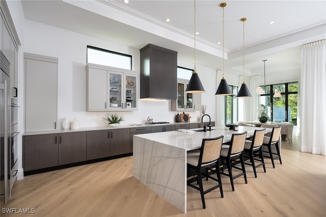 6705 Newport Rd, Naples, FL 34109 - kitchen featuring light wood finished floors, a kitchen breakfast bar, stainless steel appliances, a large island with sink, and recessed lighting