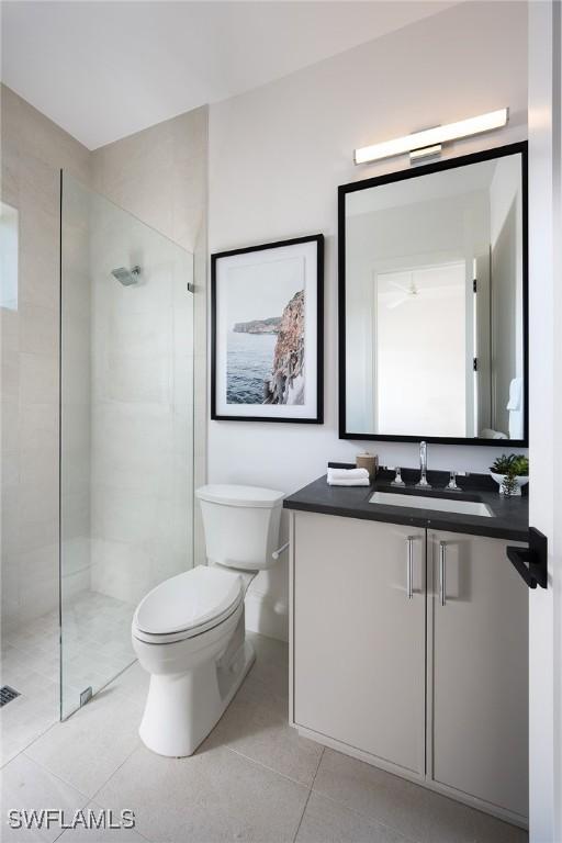 6705 Newport Rd, Naples, FL 34109 - bathroom featuring tile patterned flooring, a stall shower, toilet, and vanity