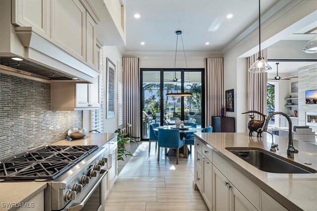 kitchen with hanging light fixtures, an island with sink, a kitchen bar, high quality fridge, and sink