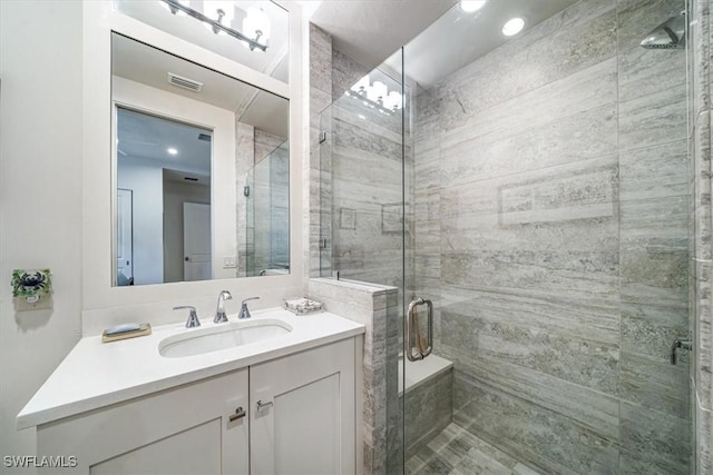 bedroom with ensuite bath, ceiling fan, multiple windows, and light hardwood / wood-style flooring