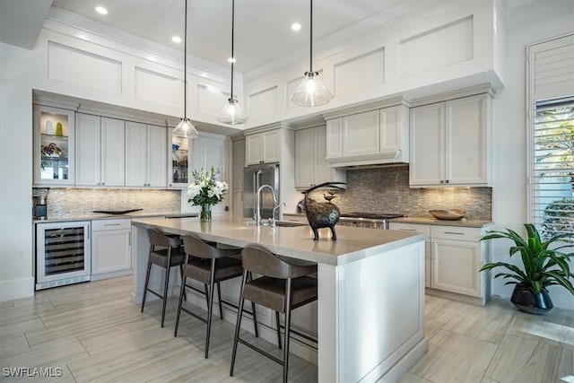 kitchen featuring a large island, hanging light fixtures, and stainless steel fridge