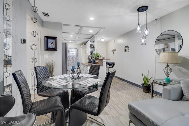 dining space featuring recessed lighting, coffered ceiling, visible vents, baseboards, and light wood-style floors