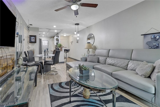 living room with ceiling fan and light hardwood / wood-style flooring