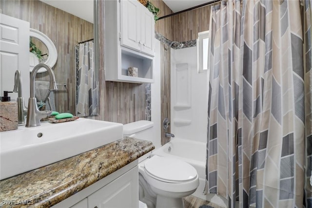 bathroom with shower / bathtub combination with curtain, toilet, wooden walls, and vanity