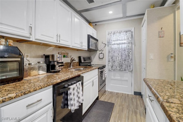 kitchen featuring sink, black appliances, stone counters, light hardwood / wood-style floors, and white cabinetry