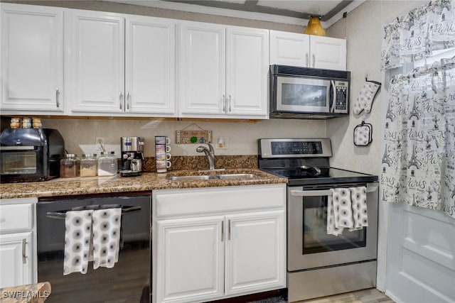 kitchen with white cabinetry, sink, appliances with stainless steel finishes, and dark stone counters