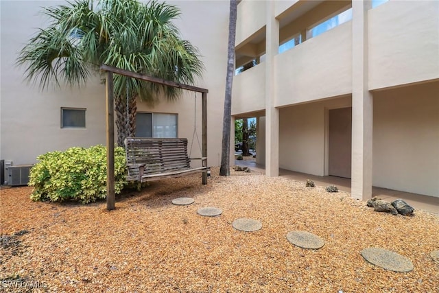 view of side of property with central AC unit and stucco siding