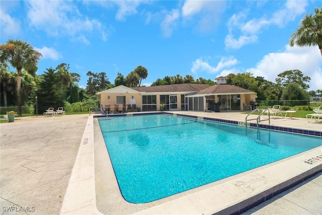 community pool featuring a patio area and fence