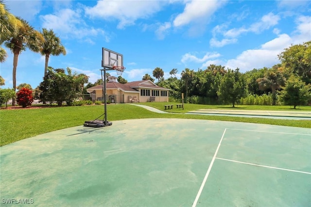 view of basketball court with a yard