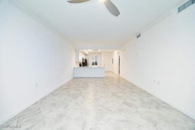 unfurnished living room with ceiling fan, visible vents, and baseboards