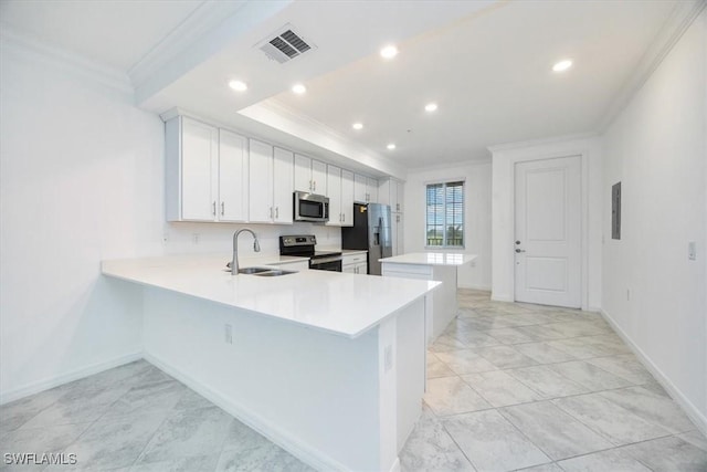 kitchen with visible vents, white cabinets, a peninsula, stainless steel appliances, and light countertops