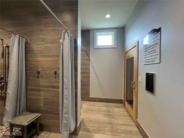 interior space with a stall shower, wood finished floors, and baseboards