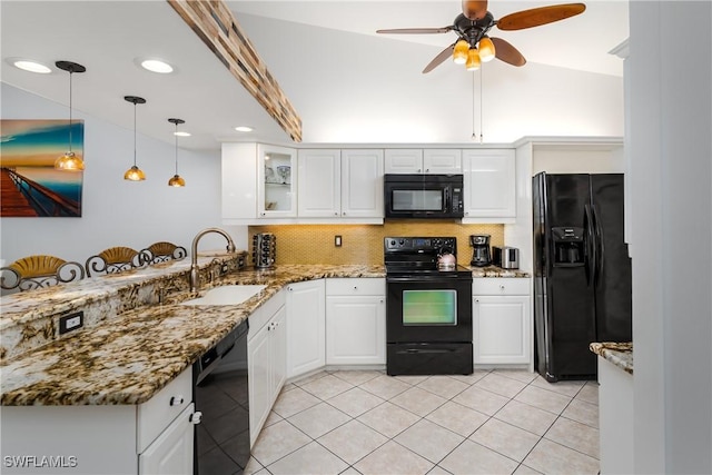 kitchen featuring white cabinetry, decorative light fixtures, dark stone counters, black appliances, and sink