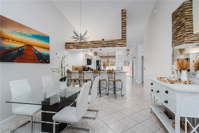 6750 Beach Resort Dr Unit 10, Naples, FL 34114 - dining area featuring baseboards, high vaulted ceiling, light tile patterned floors, and a chandelier